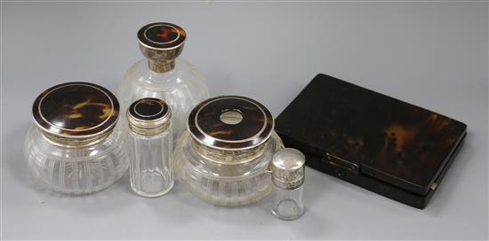 Four silver and tortoiseshell mounted glass toilet jars, a silver mounted scent bottle and a tortoiseshell vanity box.